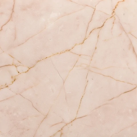 Muestra de porcelanato efecto mármol rosa con vetas doradas